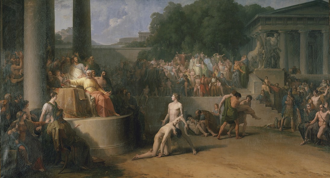 Large classical painting entitled the Olympic Games, painted by Jean-Pierre Saint-Ours. The artwork is showing an ancient public spectacle, with a ruler seated on a raised platform to the left, crowds gathered among columns and temples, and nearly nude figures in the foreground engaged in dramatic, ritual-like action within a grand architectural setting.